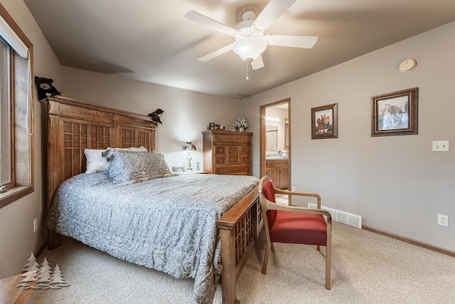 carpeted bedroom with connected bathroom, baseboards, and ceiling fan