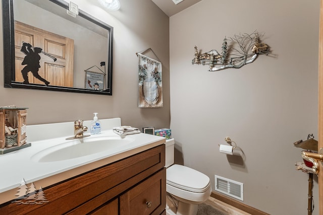 bathroom with visible vents, toilet, and vanity