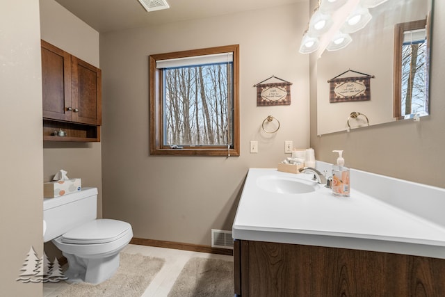 half bathroom featuring tile patterned flooring, visible vents, baseboards, toilet, and vanity