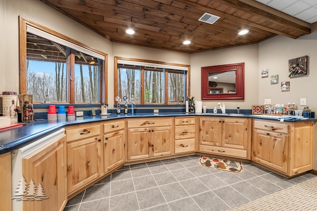 kitchen featuring wood ceiling, visible vents, light brown cabinetry, and a sink