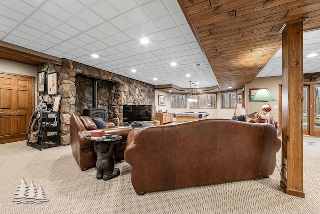 living area with light carpet, visible vents, and a wood stove