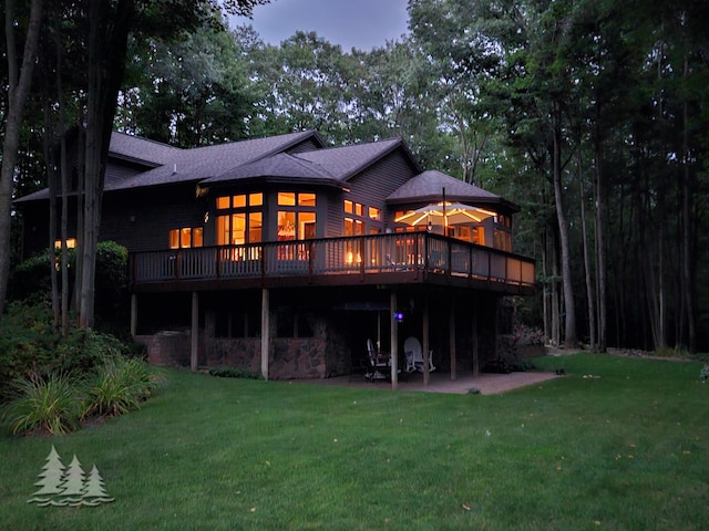 rear view of house with a patio, a lawn, and a deck