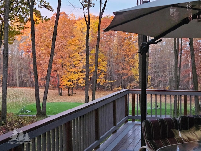 wooden terrace featuring a wooded view