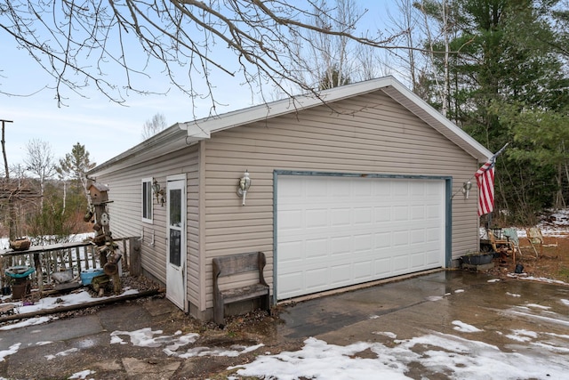 snow covered garage featuring a detached garage