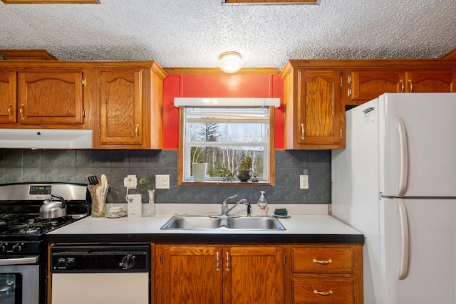 kitchen featuring a sink, under cabinet range hood, white appliances, brown cabinetry, and decorative backsplash