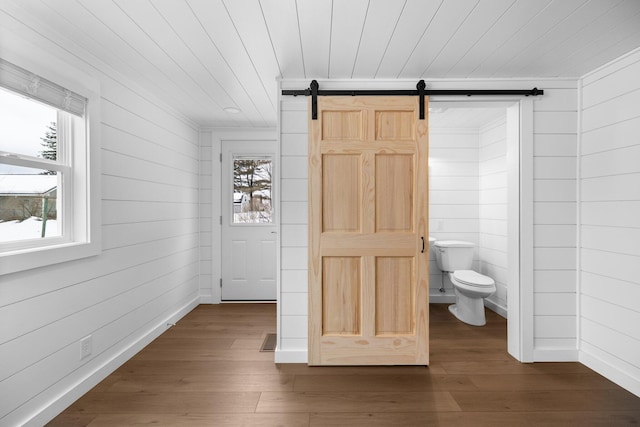 interior space with plenty of natural light, toilet, and hardwood / wood-style floors