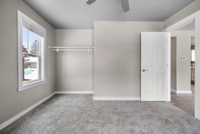 unfurnished bedroom featuring a closet, a ceiling fan, baseboards, and carpet floors