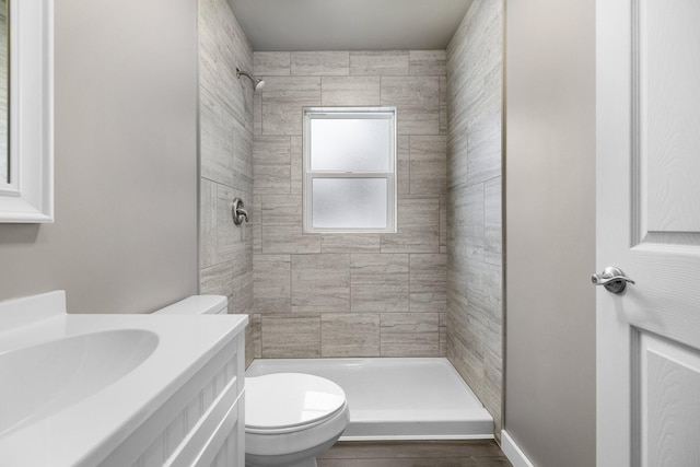 full bathroom featuring wood finished floors, toilet, a stall shower, and vanity