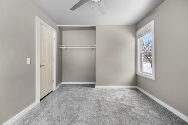 unfurnished bedroom with baseboards, carpet floors, a closet, and a ceiling fan