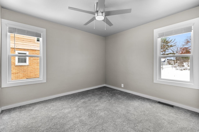 carpeted spare room with a ceiling fan, baseboards, and visible vents