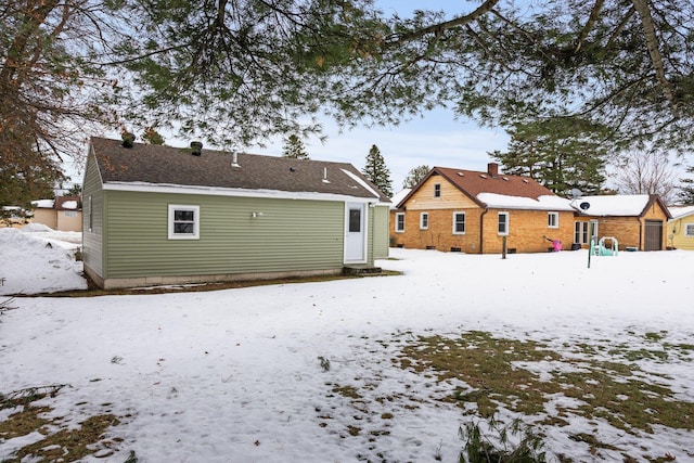 snow covered property with a detached garage