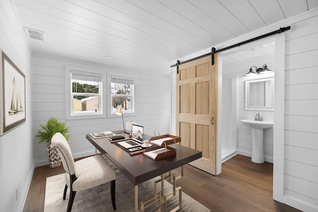 office with visible vents, wood ceiling, dark wood-type flooring, and a barn door