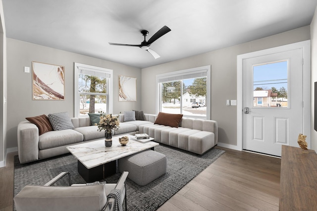 living area with ceiling fan, baseboards, and wood finished floors