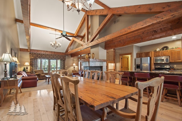 dining room featuring visible vents, an inviting chandelier, light wood-style flooring, and a fireplace