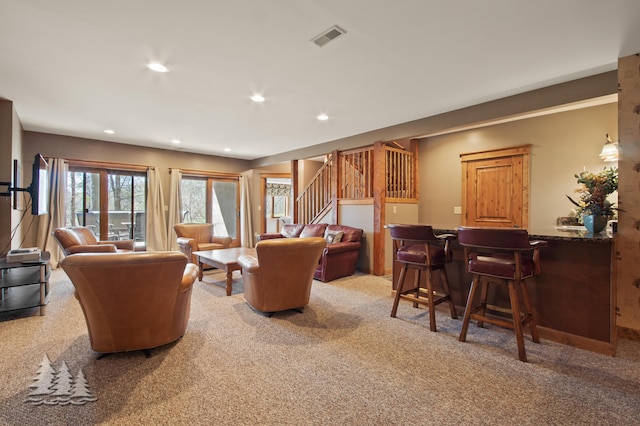 carpeted living room featuring visible vents, recessed lighting, stairway, and a dry bar