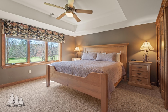 bedroom featuring a raised ceiling, carpet flooring, baseboards, and visible vents