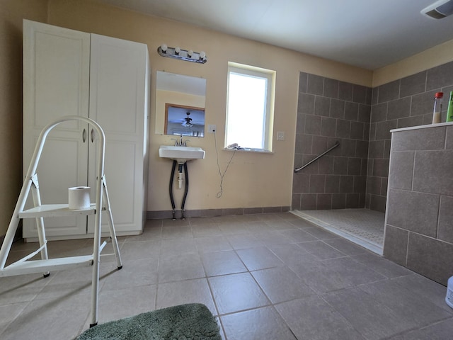 bathroom with visible vents, a walk in shower, baseboards, tile patterned floors, and a sink