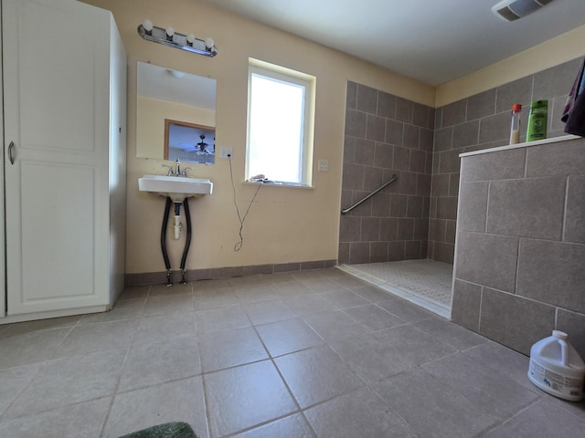 bathroom featuring tile patterned flooring, visible vents, a walk in shower, and baseboards