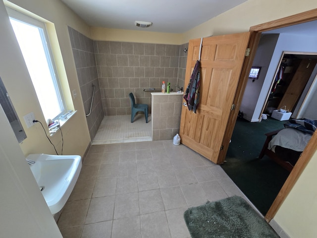 bathroom with tile patterned flooring, visible vents, a walk in shower, and a sink