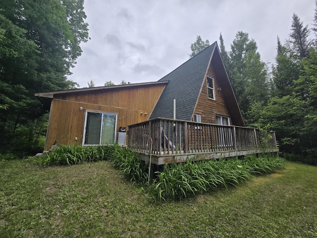 2709 Timberlane Trl, Grayling, MI 49738 - rear view of house with a wooden deck, a shingled roof, and a lawn