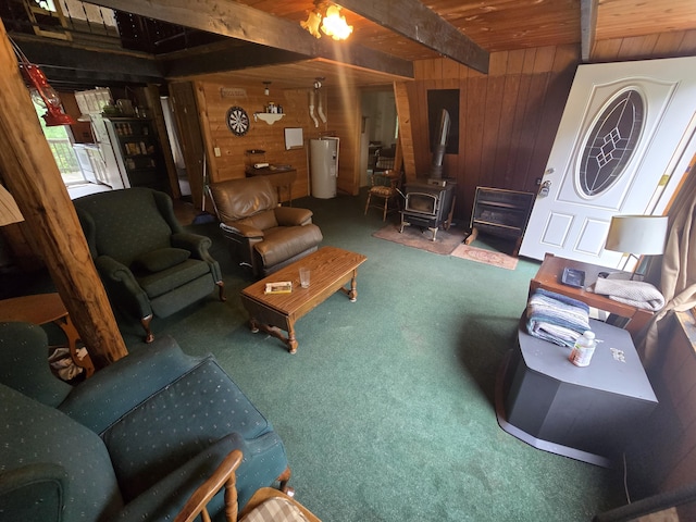 2709 Timberlane Trl, Grayling, MI 49738 - living room featuring wooden walls, electric water heater, carpet flooring, a wood stove, and a wooden ceiling with exposed beams