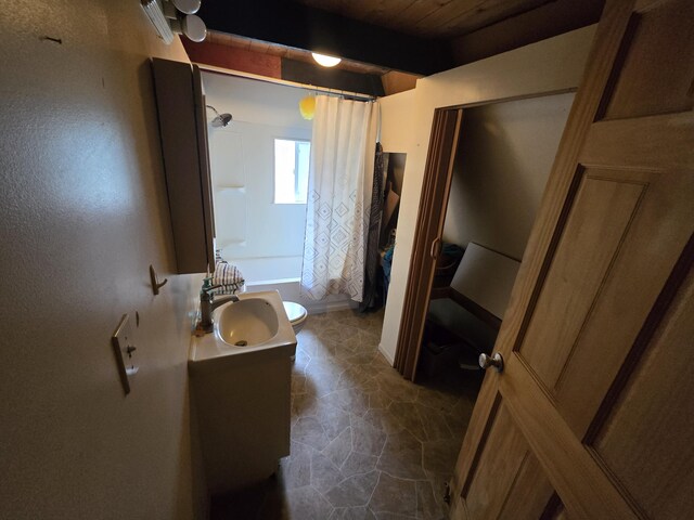 2709 Timberlane Trl, Grayling, MI 49738 - bathroom with vanity, shower / tub combo with curtain, and beamed ceiling