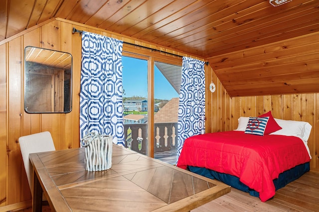 bedroom with wooden walls, access to outside, wood finished floors, vaulted ceiling, and wooden ceiling