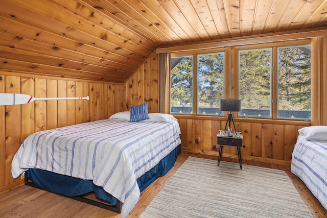 bedroom with vaulted ceiling, wood finished floors, wood walls, and wood ceiling