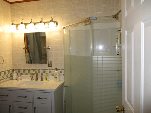 bathroom featuring vanity, backsplash, tile walls, and a shower stall