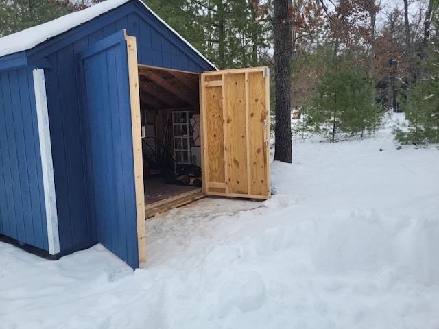 snow covered structure featuring an outdoor structure