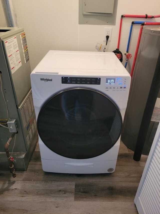 washroom with washer / dryer, wood finished floors, water heater, and laundry area