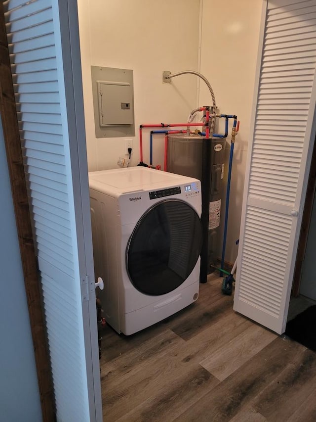 washroom featuring wood finished floors, laundry area, electric panel, washer / clothes dryer, and electric water heater