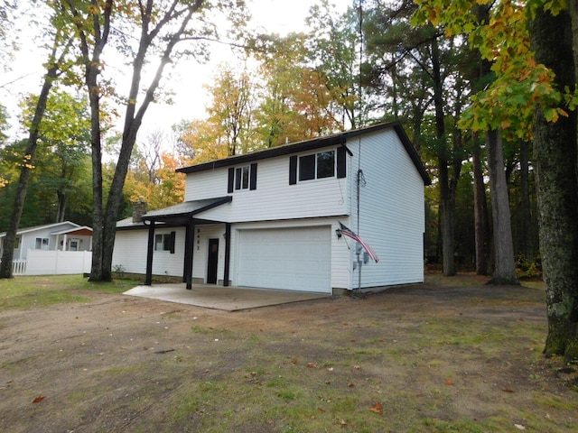 view of front of house featuring driveway, an attached garage, and fence