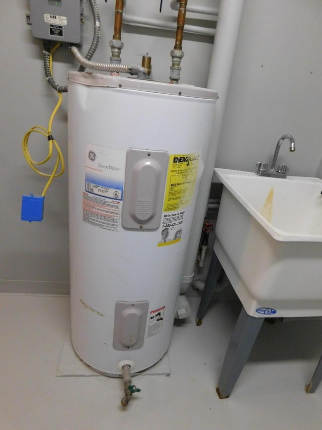 utility room featuring a sink and electric water heater