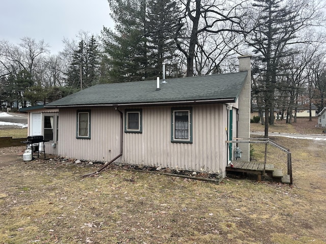 view of front of property with roof with shingles and a chimney