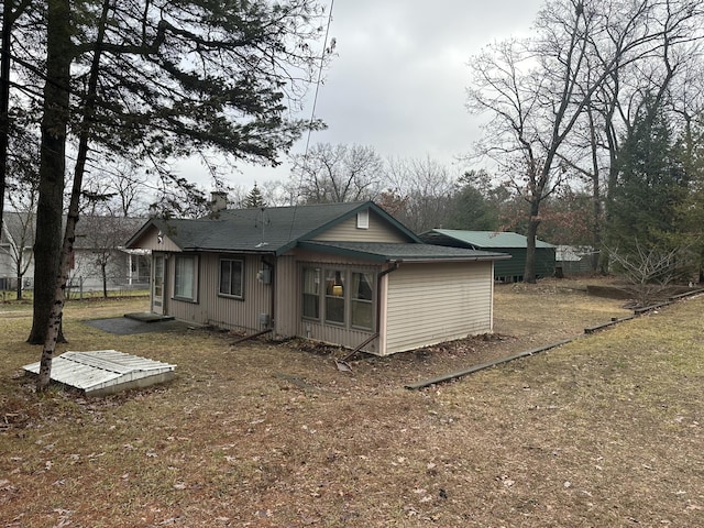 back of house featuring a chimney