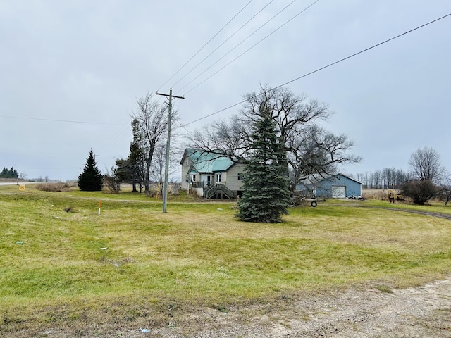 view of yard with stairway, a garage, and driveway