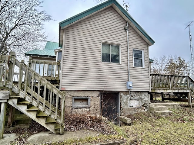 view of home's exterior featuring metal roof, a deck, and stairs