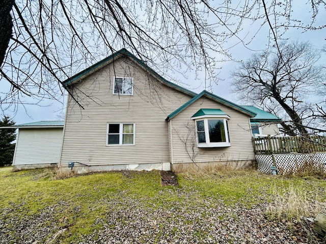 rear view of property featuring a deck and a yard