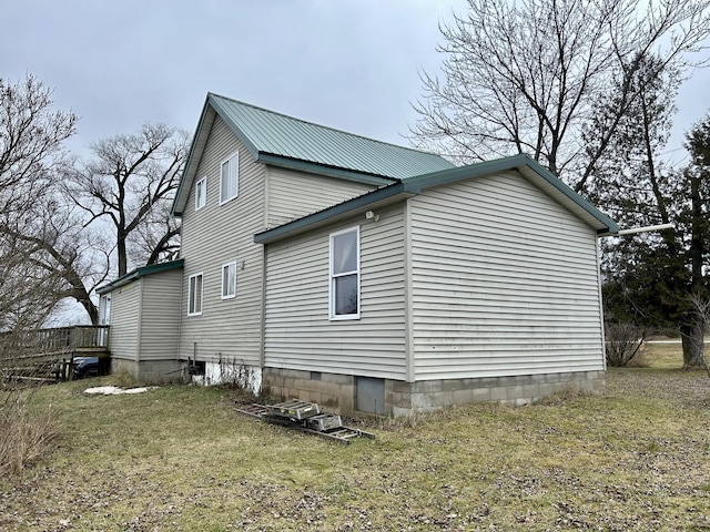 view of side of home with metal roof and a yard