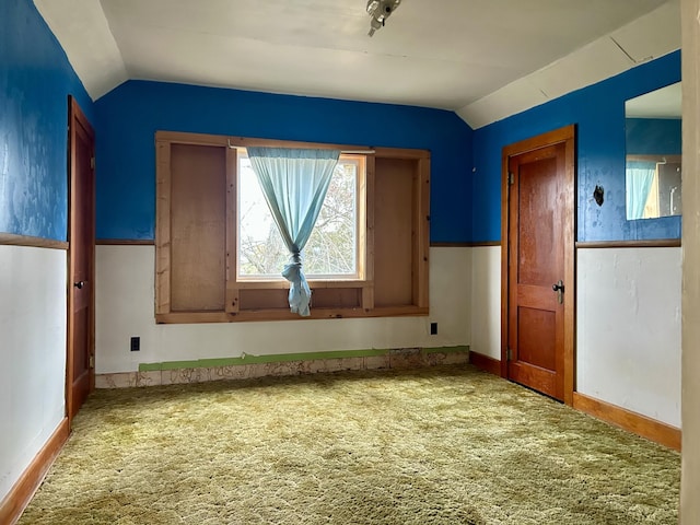 carpeted spare room featuring lofted ceiling