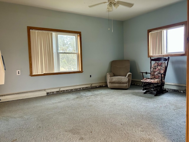 unfurnished room featuring a wealth of natural light, a baseboard heating unit, ceiling fan, and carpet floors