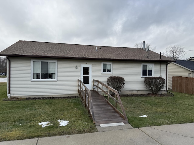 single story home with a front lawn, fence, and roof with shingles