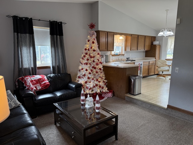 living room with light carpet, baseboards, high vaulted ceiling, and an inviting chandelier