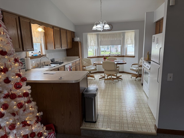 kitchen with light countertops, plenty of natural light, white appliances, and a sink