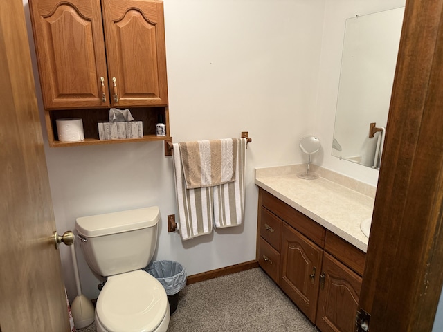 bathroom featuring baseboards, toilet, and vanity