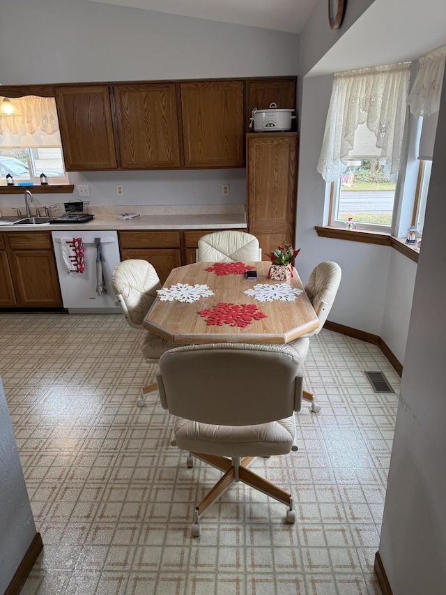 dining room featuring visible vents, light floors, lofted ceiling, and baseboards