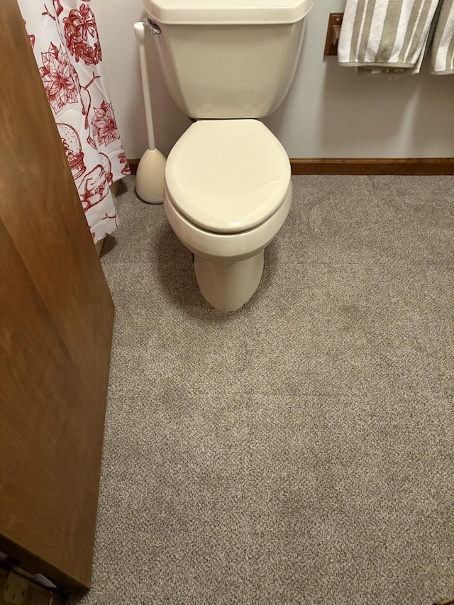 bathroom featuring baseboards and toilet