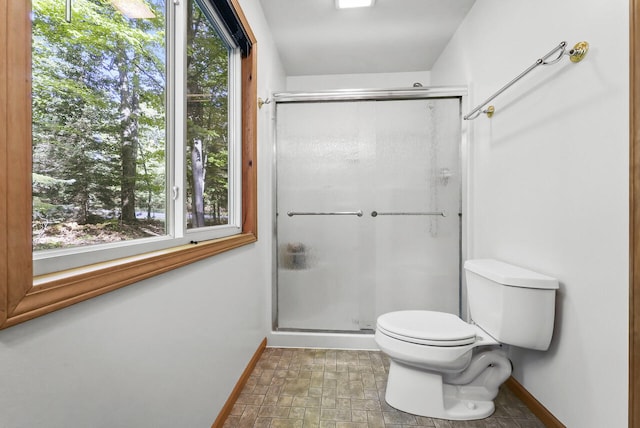 full bathroom featuring a shower stall, toilet, and baseboards