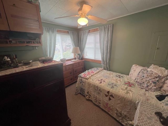 bedroom with ceiling fan, electric panel, and light carpet